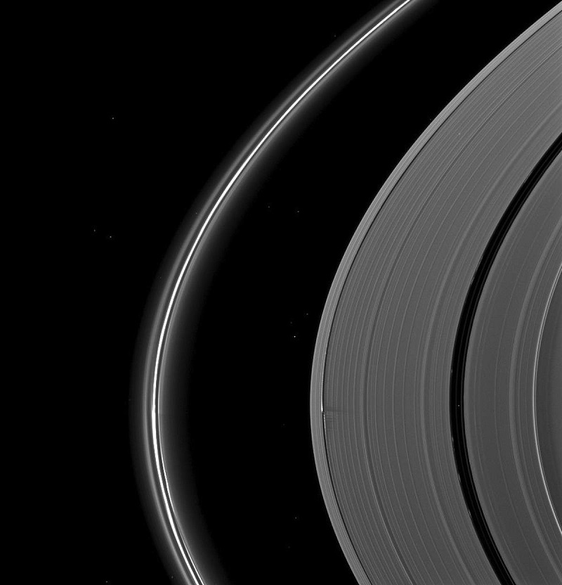 در این تصویر، پایین تر از مرکز، یکی از چهار قمر شپرد زحل، با نام دفنیس، به خوبی نشان داده شده است. این قمر های بسیار کوچک که با فاصله ی نزدیکی از زحل در حال گردش هستند، به طور مداوم حلقه های آن را قطع می کنند. 