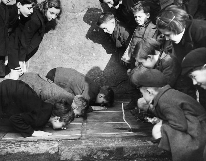 بچه‌ها در حال بازی "بادام زمینی رو هل بده" هستند، خیابانی در King's Cross لندن، 1938