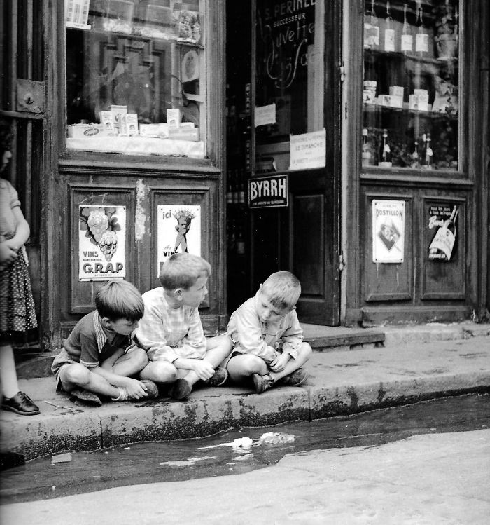 کودکانی در حال بازی با قایق‌های کاغذی در کنار خیابان، پاریس، دهه 1950
