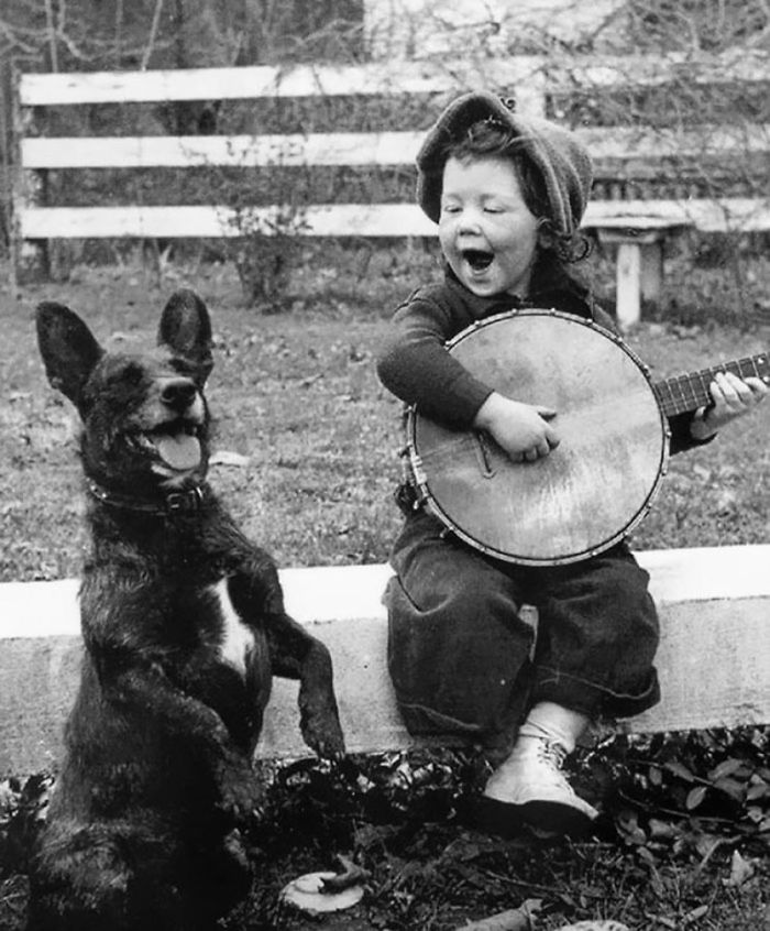 دختری در حال گیتار زدن برای سگش 